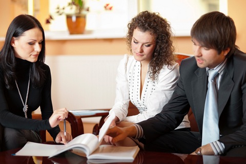 Couple with Agent Reviewing Paperwork Couple with Agent Reviewing Paperwork